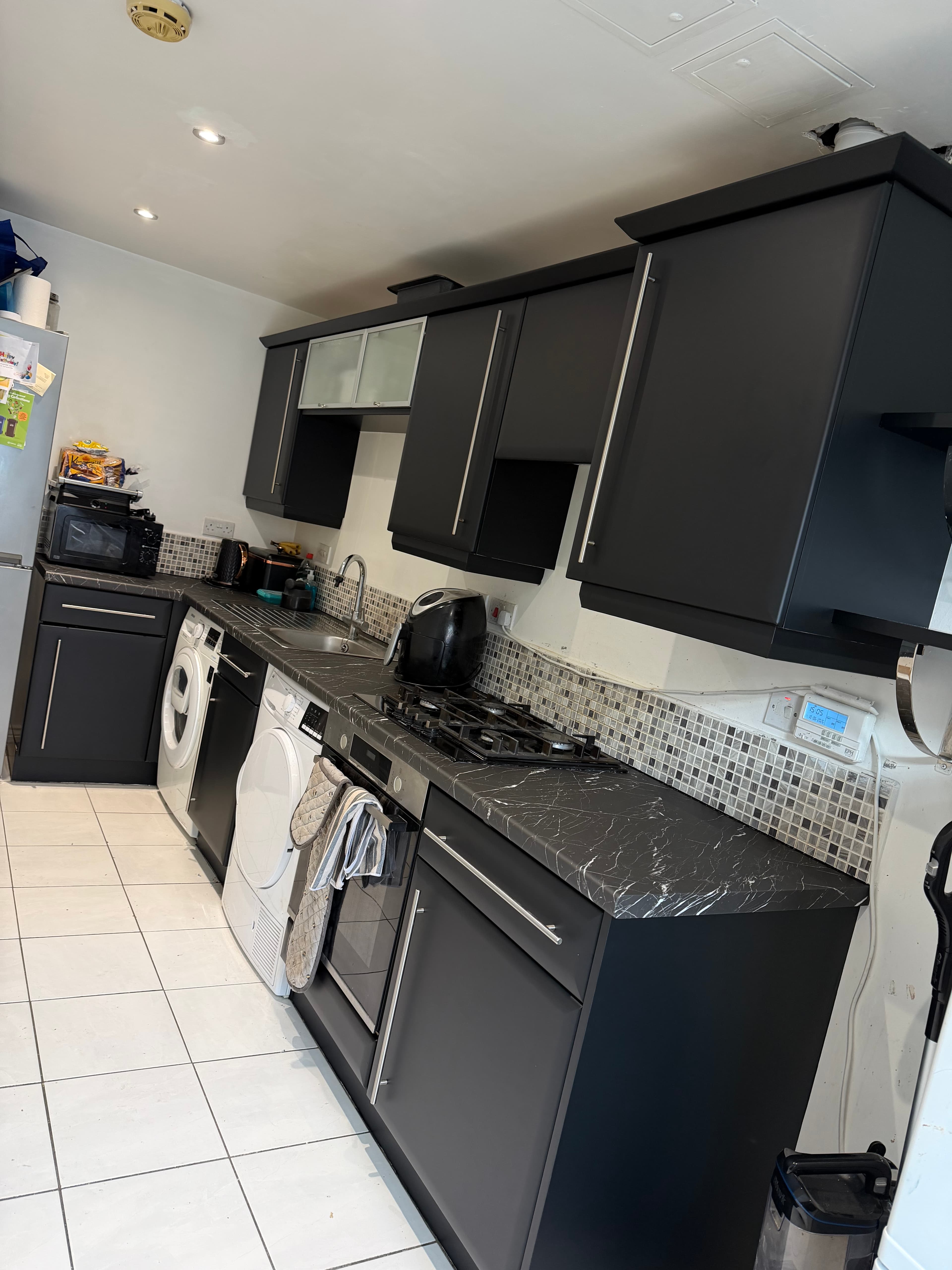 Matt black kitchen wrap with marble-effect worktops in Sheffield